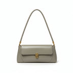 Green handbag hanging on a door handle against a white wall.