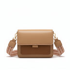 Beige handbag held by a person wearing a beige coat