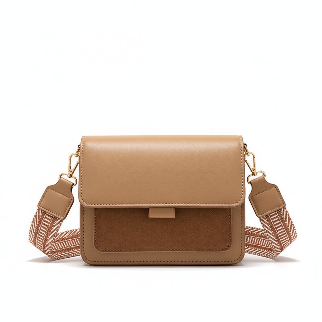 Beige handbag held by a person wearing a beige coat