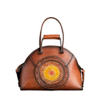 Brown leather handbag with floral embossing on a textured brown background