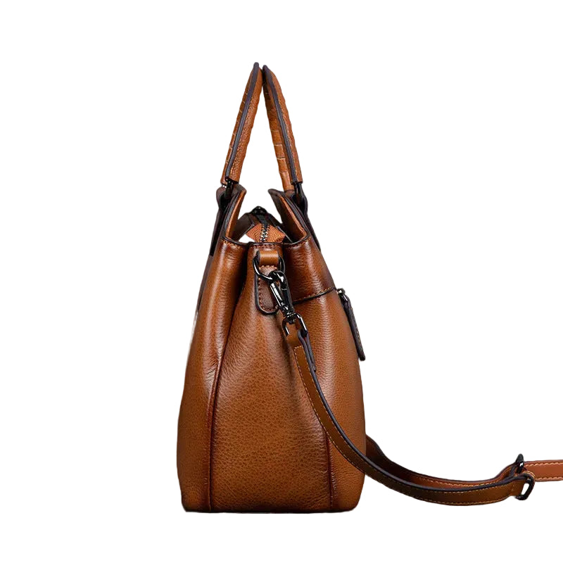 Brown leather handbag on a textured surface with a dark background