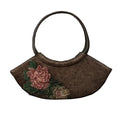 Brown handbag with floral embroidery on a textured brown background