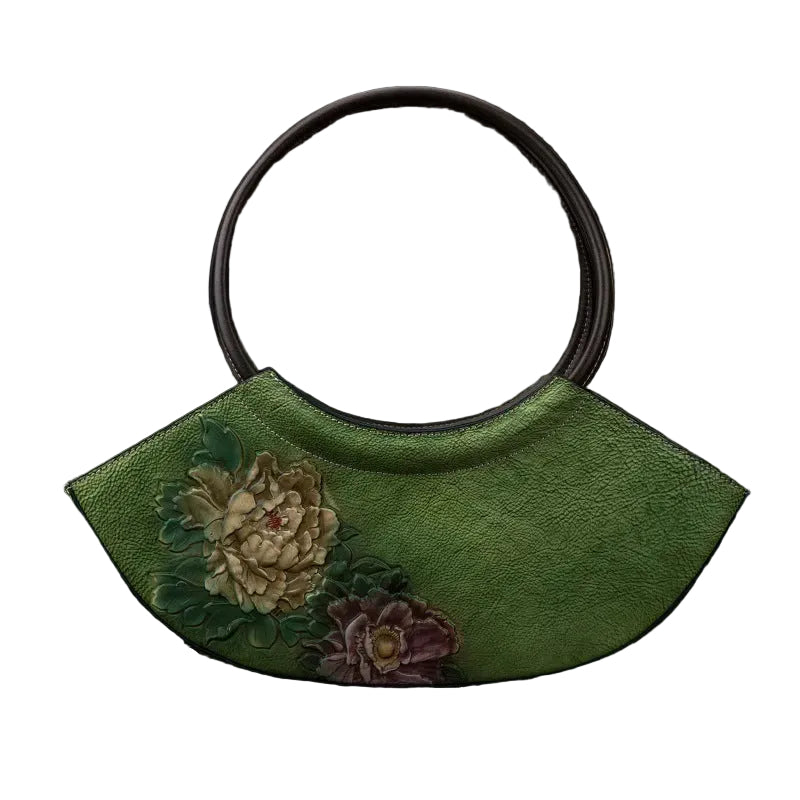 Green handbag with floral designs on a textured brown background
