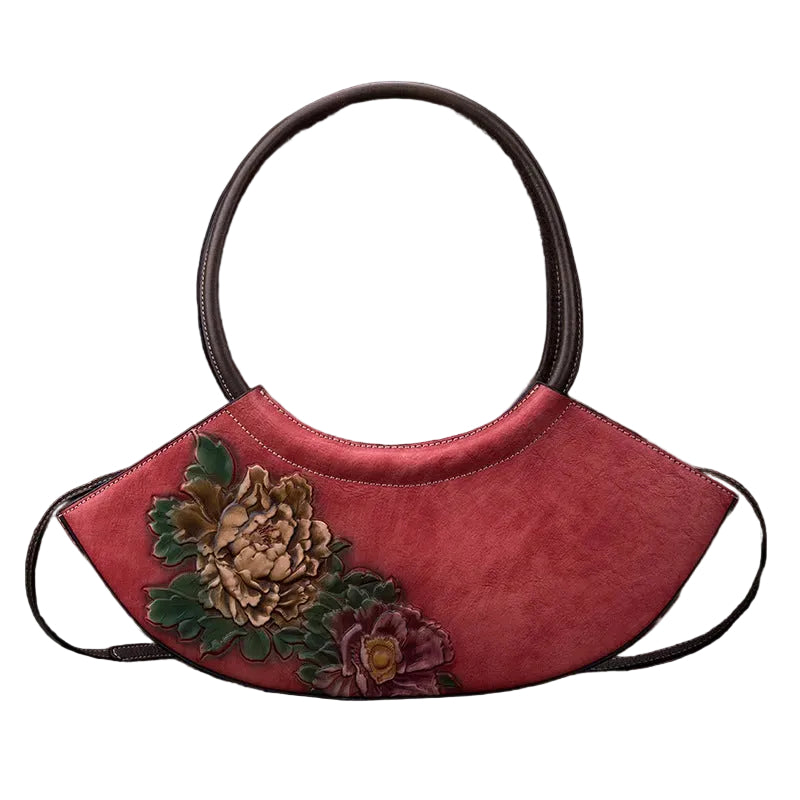 Red handbag with floral designs on a textured gray background