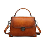 Brown leather handbag on a dark surface with a gray background