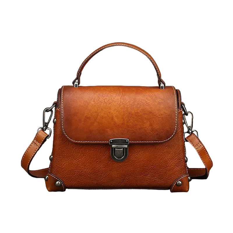 Brown leather handbag on a dark surface with a gray background