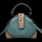 Teal handbag with floral embroidery on a neutral background