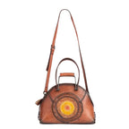 Brown leather handbag with a decorative circular design on a white background