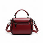 Red handbag on a wooden surface with a brown curtain background