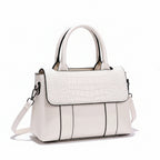 White handbag with a textured pattern on a white surface with a brown background
