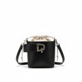 Black handbag with a bottle of perfume on a white fabric background