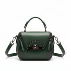 Green handbag on a wooden stand with 'ORIGINALS' branding on a wooden surface.