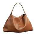 Brown leather handbag on a dark surface with a white background