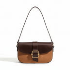 Brown and beige handbag with a gold buckle on a beige background
