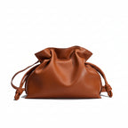 Brown leather drawstring bag on a light gray background