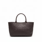 Woven handbag on a wooden floor with a white wall background