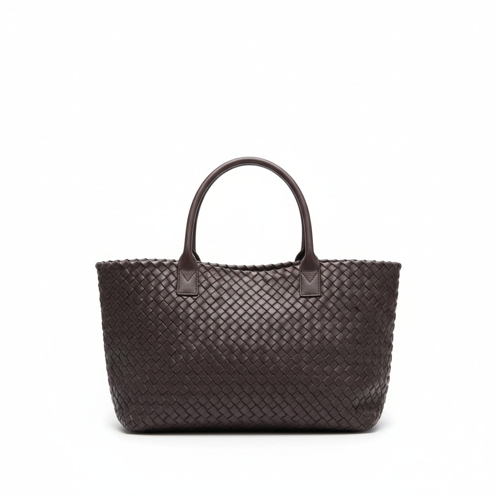 Woven handbag on a wooden floor with a white wall background