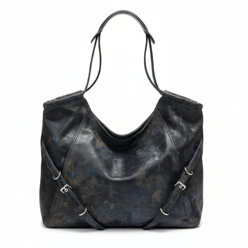 Black leather handbag on a hanger against a neutral wall.