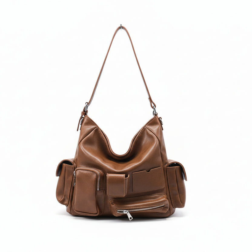 Brown leather handbag hanging on a rack with a store interior in the background