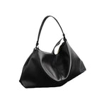 Black handbag on a dark surface with a white background