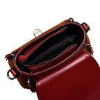 Brown leather handbag with open top on a wooden surface