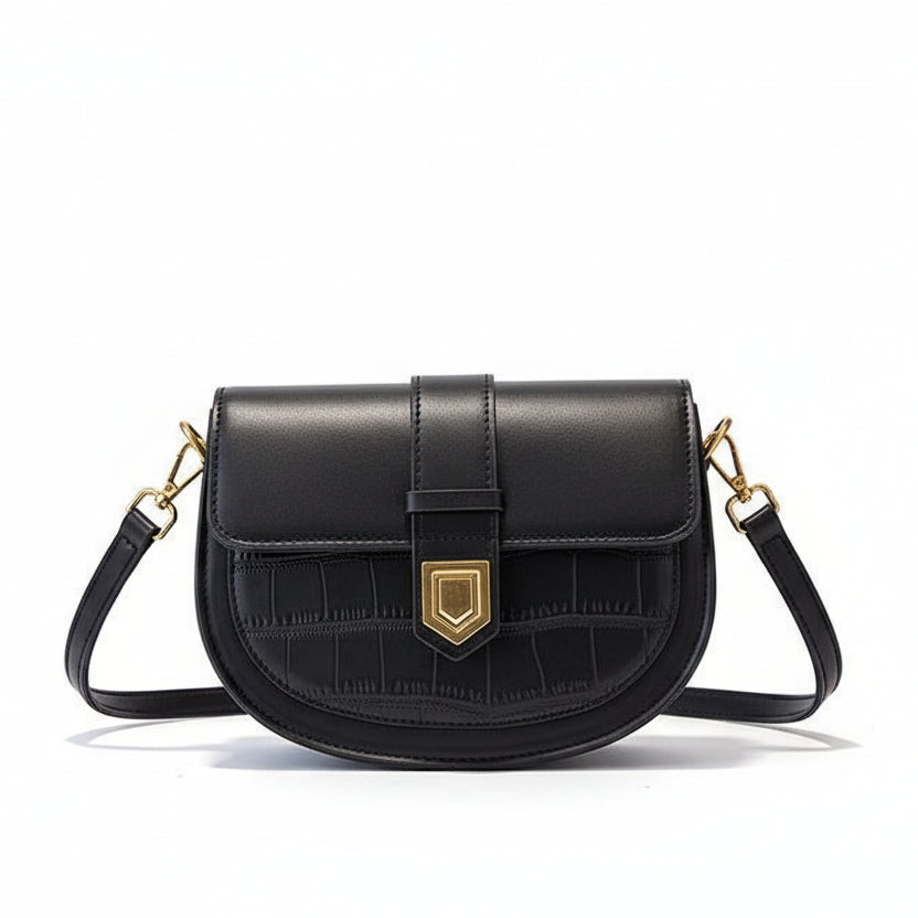 Black handbag with gold hardware on a beige coat