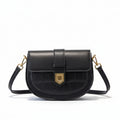 Black handbag with gold hardware on a beige coat