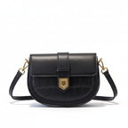 Black handbag with gold hardware on a beige coat