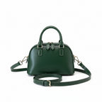 Green handbag on a magazine with a blurred indoor background