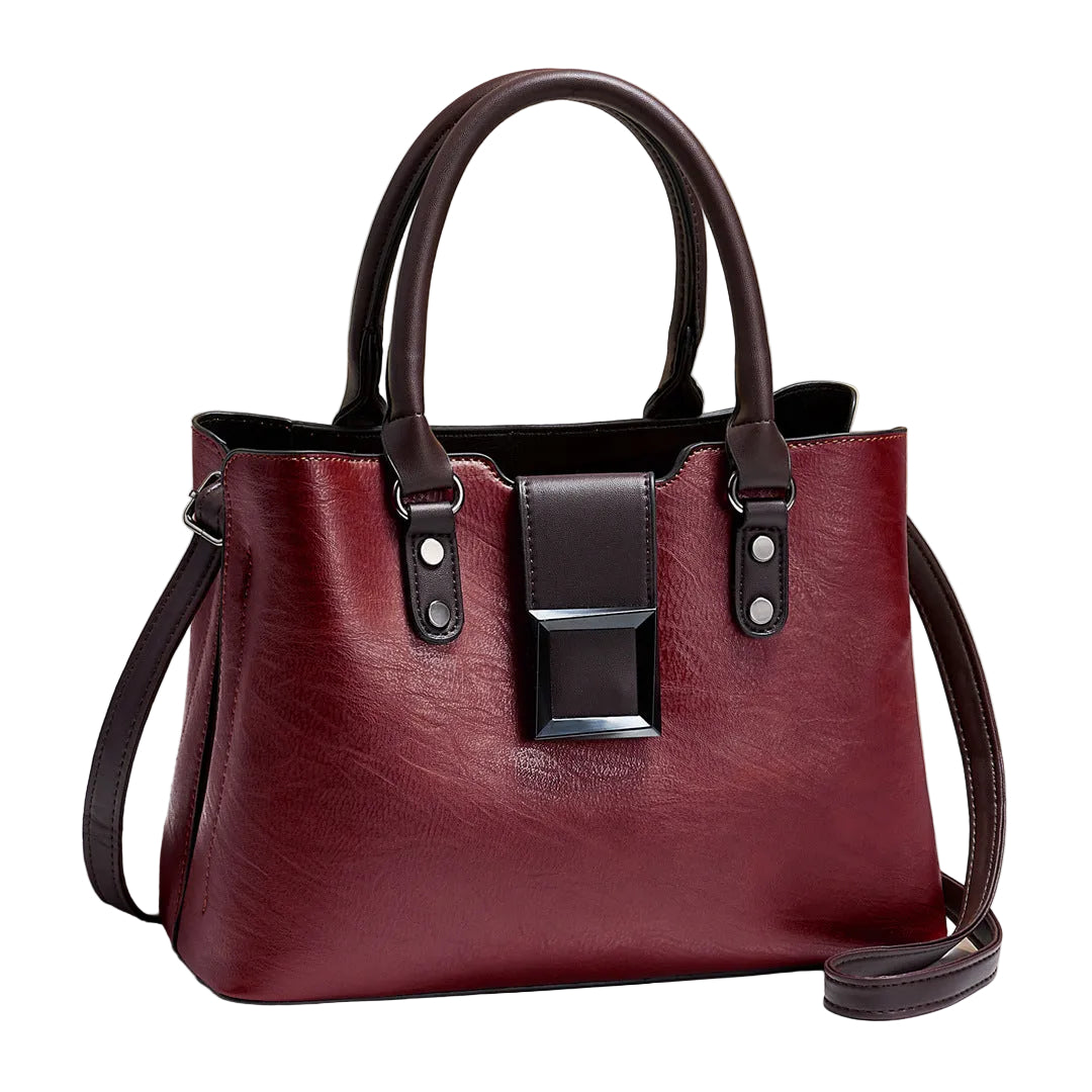 Red handbag with black accents on a light surface with a beige background
