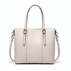 White handbag with silver handles and zippers on a light gray background