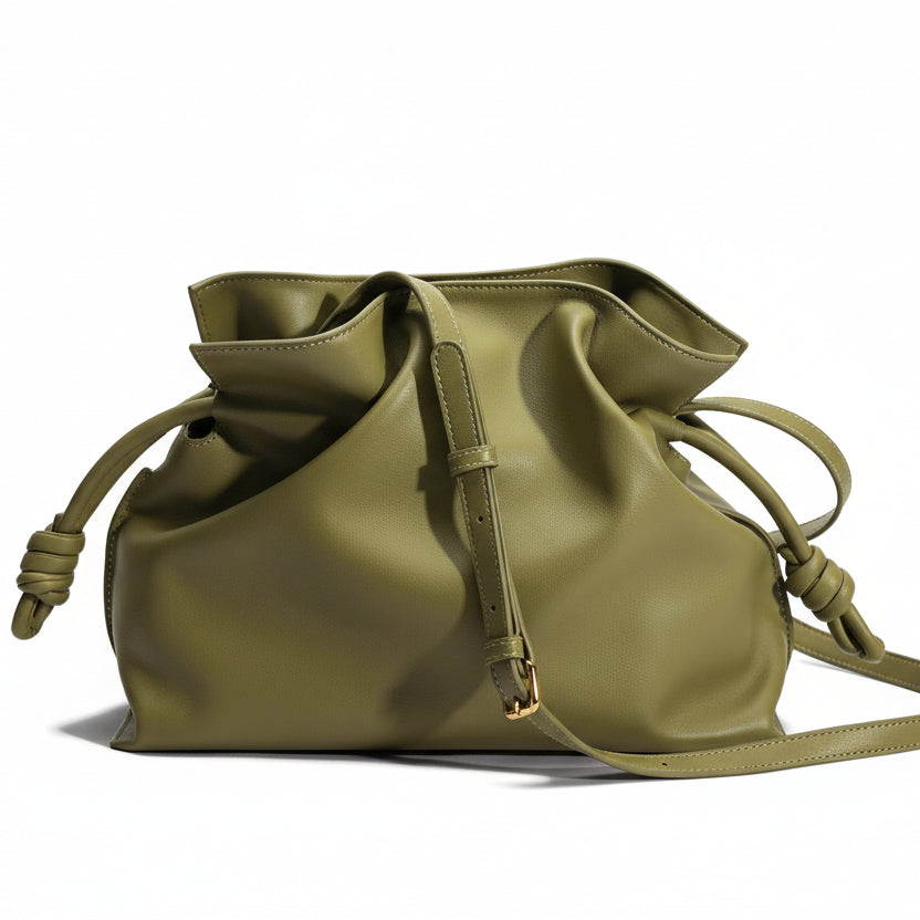 Green leather drawstring bag on a beige background
