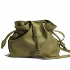 Green leather drawstring bag on a beige background