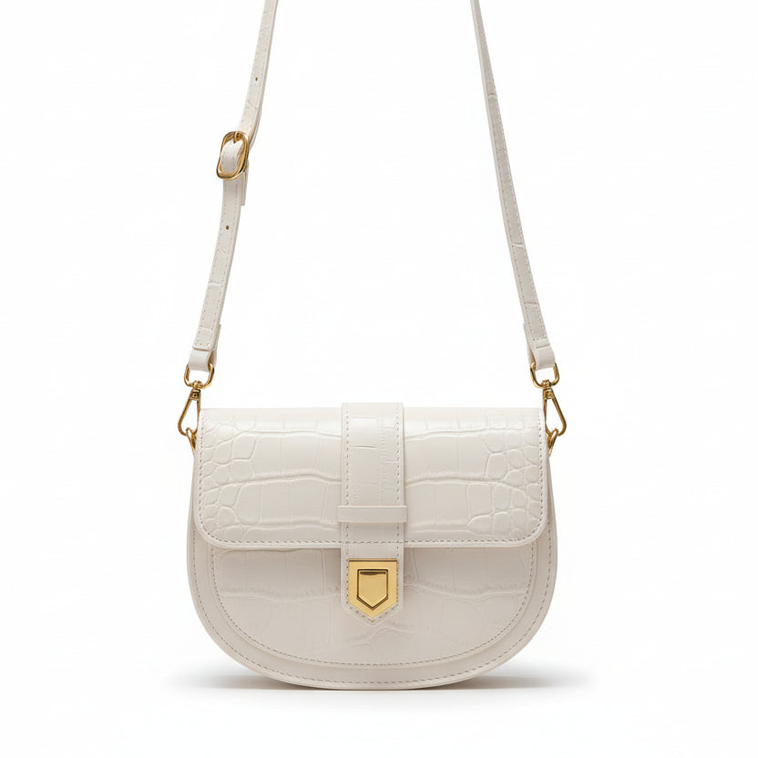 White handbag with gold accents worn by a person in a black outfit.