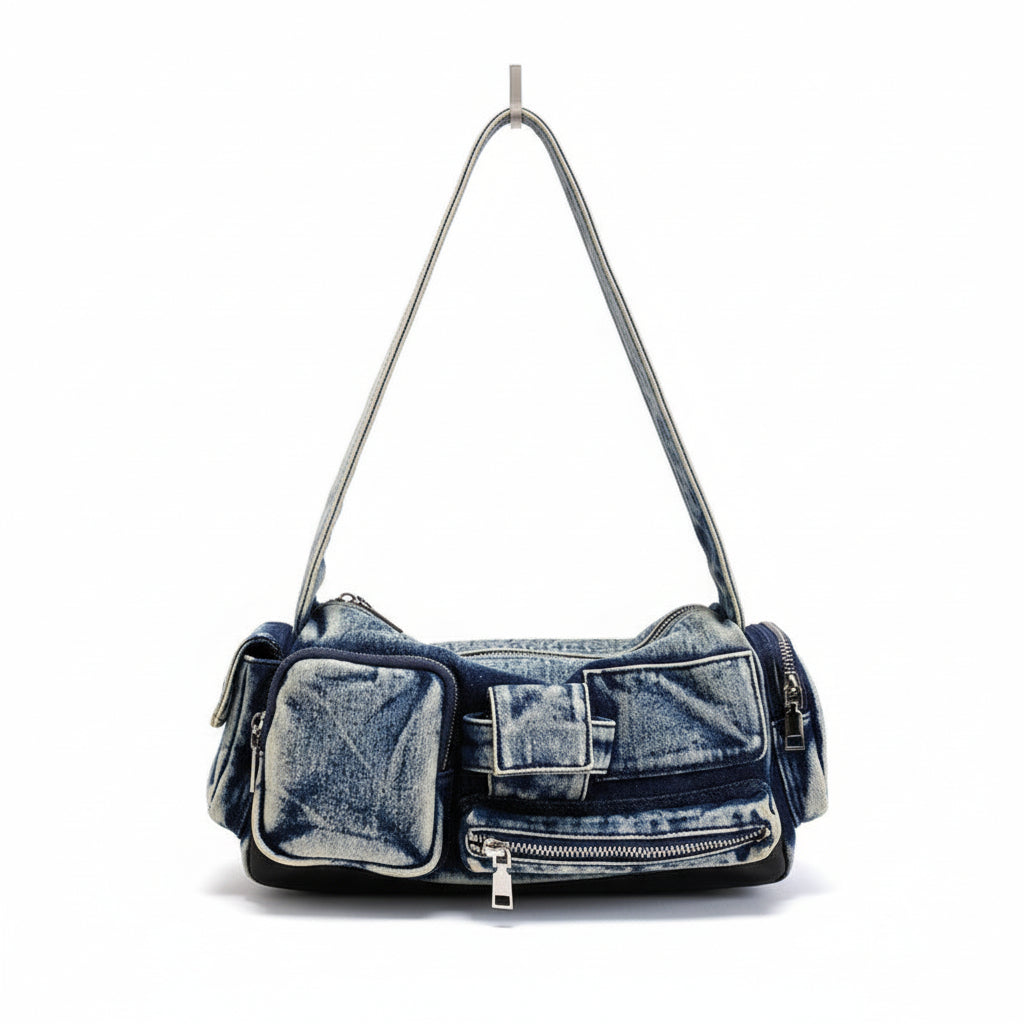 Denim handbag on a white surface with a striped garment in the background