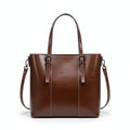 Brown leather handbag on a white cushion with a light gray background