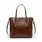 Brown leather handbag on a white cushion with a light gray background