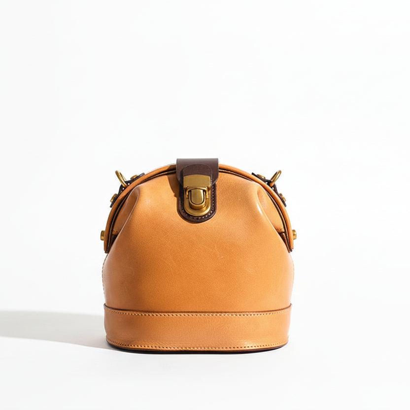 Person holding a brown leather handbag with a blurred indoor background